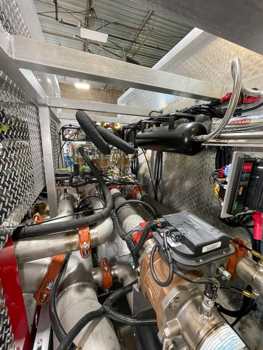 Exterior view of small fire truck showing cab, body compartments, and wheel/tire area.